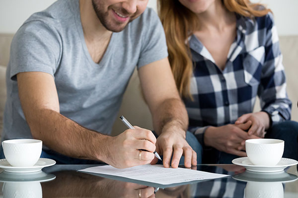 Couple signing a prenuptial agreement with a family law lawyer.